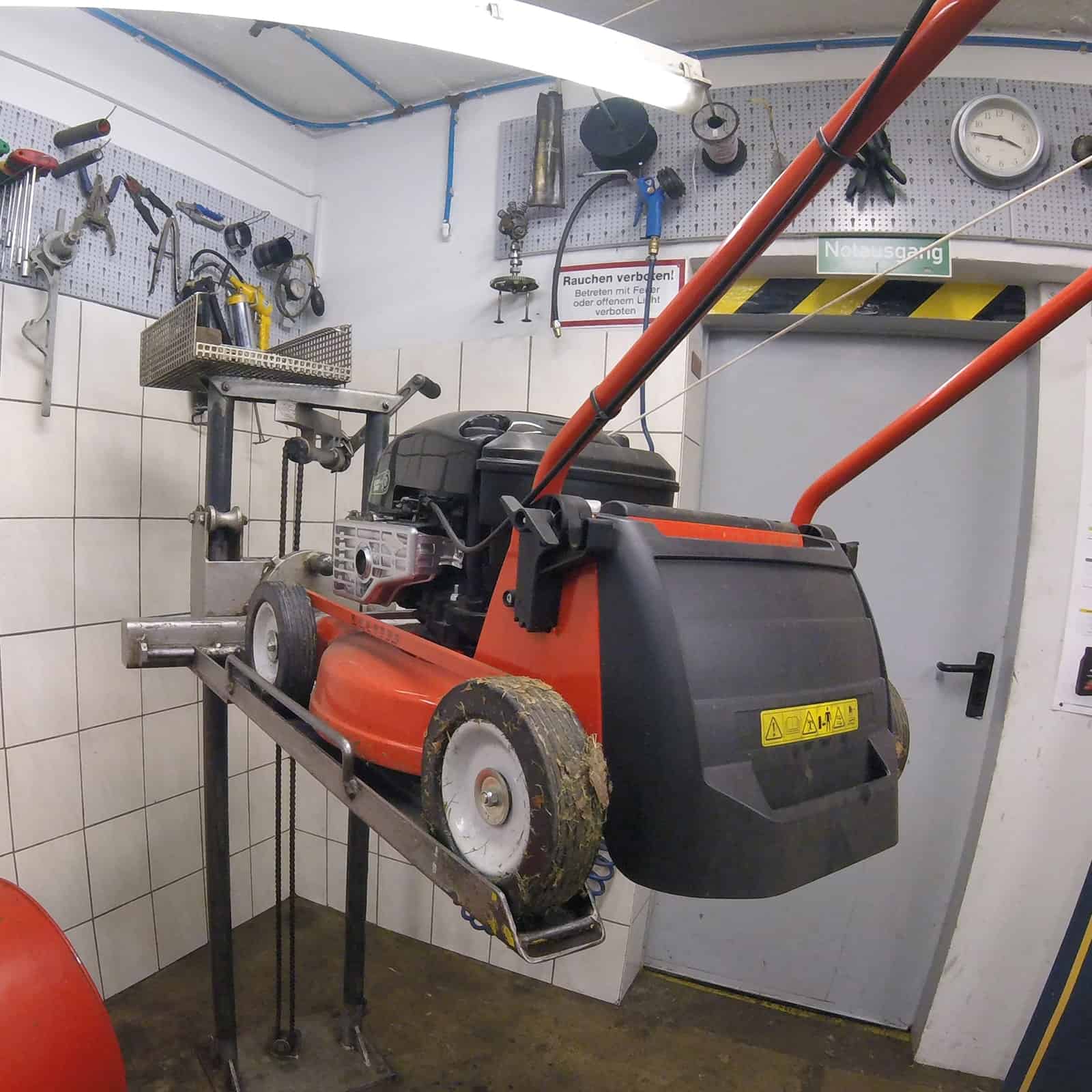 Rasenmäher auf einer Hebebühne in der Werkstatt