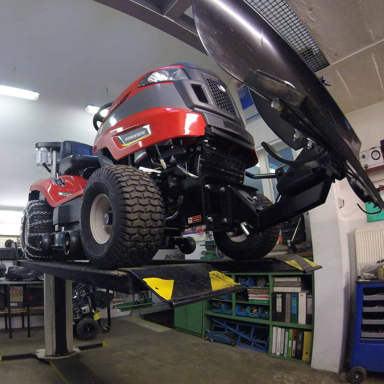 Rasentraktor auf einer Hebebühne in der Werkstatt