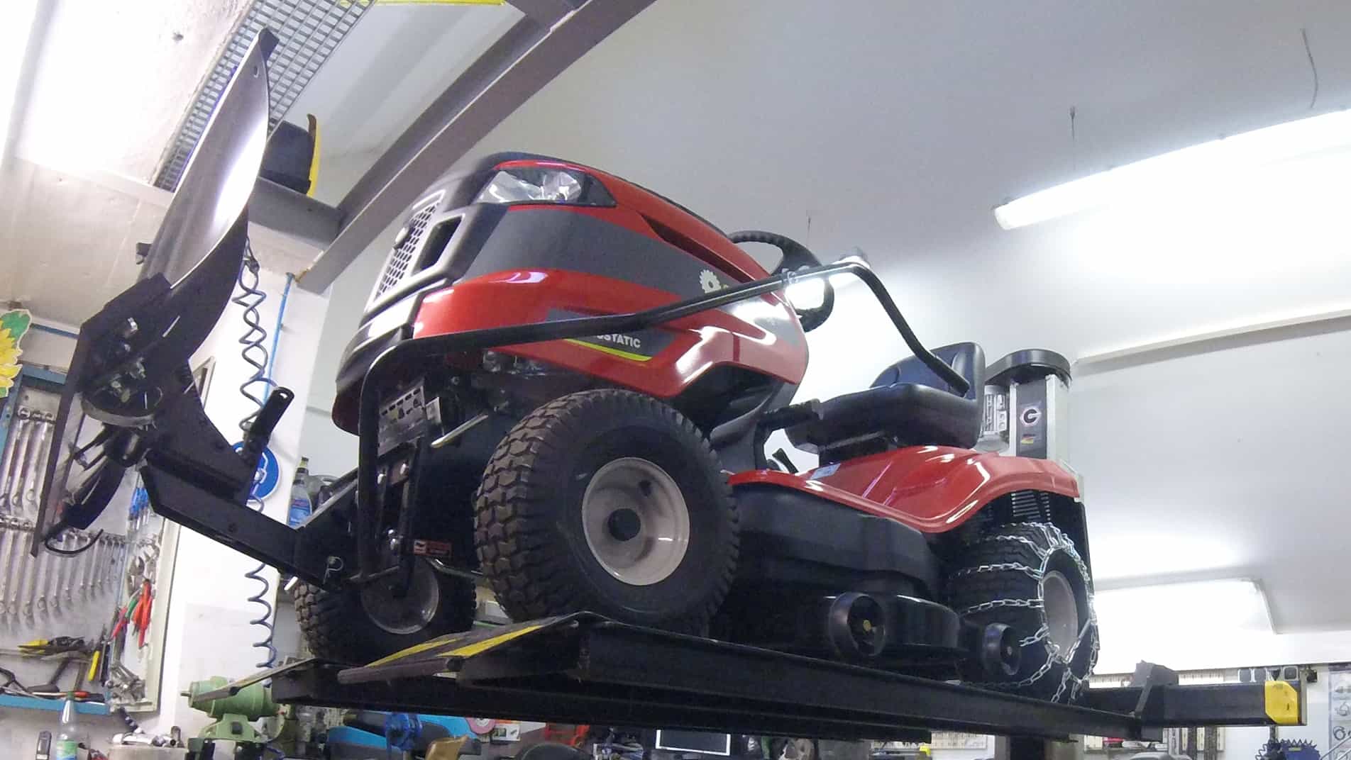 Rasentraktor auf einer Hebebühne in der Werkstatt